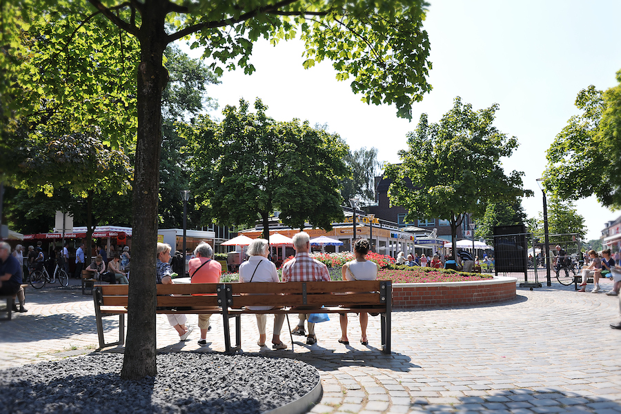 Beisammensein auf dem Tibarg Ein Platz mit vielen Menschen auf dem Tibarg. Es sitzen Menschen auf einer Bank und schauen sich das bunte Treiben an.